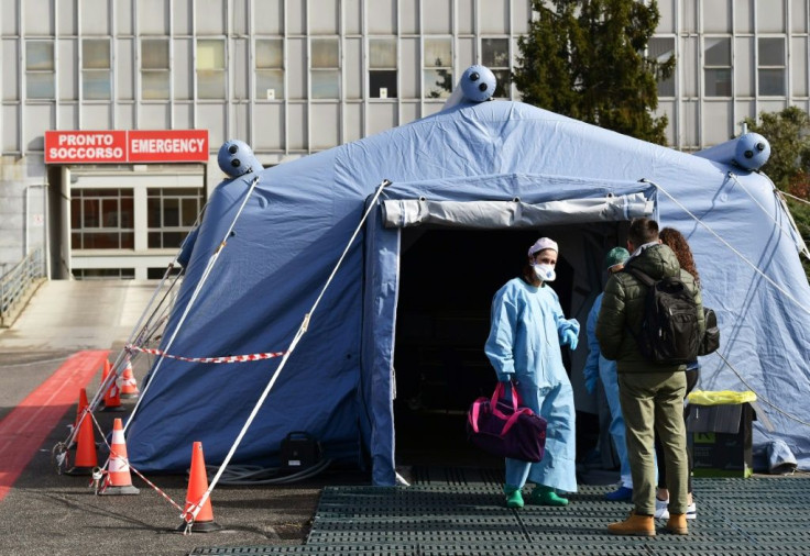 People arrive at a pre-triage medical tent in front of Cremona hospital in Italy, where the virus death toll has risen above 100
