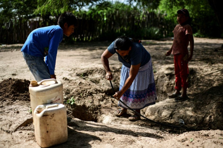 A woman takes water from a well in Mision Chaquena, near the town of Embarcacion in Argentina's northern Salta province