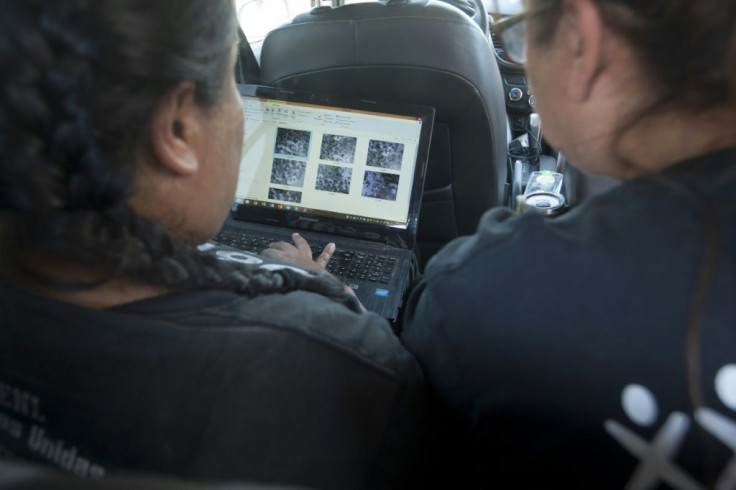 Leticia Hidalgo and Angelica Orozco, members of United Forces for our Disappeared in Nuevo Leon, look at photos taken by a drone in Salinas Victoria February 24, 2020