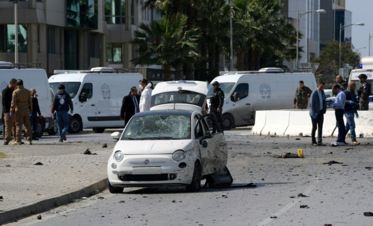 Police and forensic experts gather at the scene of an explosion near the US embassy in Tunis