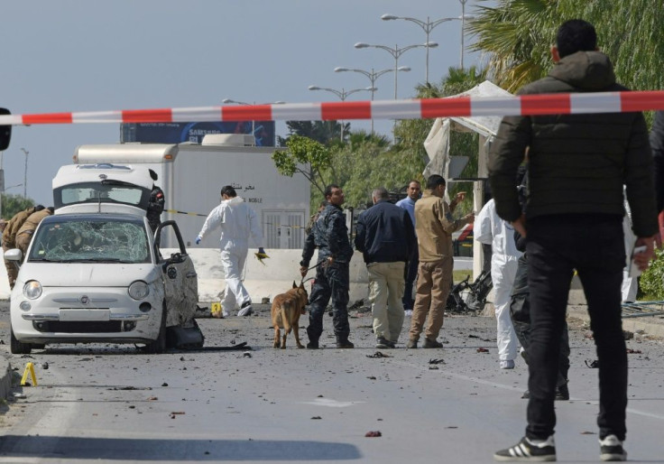 Police and forensic experts gather at the scene of a double suicide attack that targeted police near the heavily-fortified US embassy in the Tunisian capital
