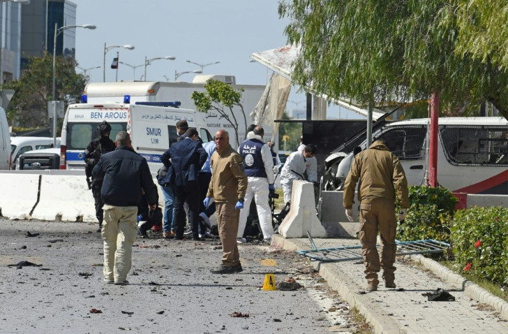 Police and forensic experts inspect the scene of a twin attack near the US embassy in Tunis
