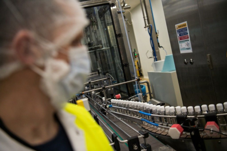 A lab employee monitors a production chain of hydroalcoholic solution -- gel producer Gilbert insists it will not hike prices in France, where the virus had claimed nine lives by Friday