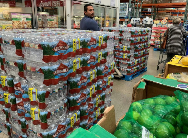 A worker wheeling a pallet of bottles back to their shelf was repeatedly stopped by new customers who grabbed what they could