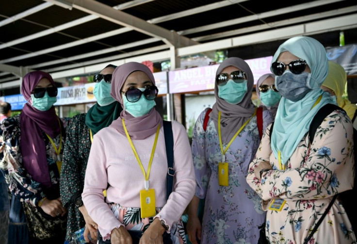 Passengers wearing facemasks prepare to board fast boats to cross from Sanur to Nusa Penida island, on the Indonesia resort island of Bali