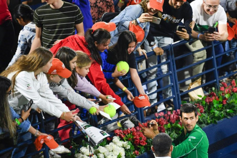 Serbia's Novak Djokovic signs autographs after winning ATP final in Dubai. The ATP and WTA tours have instructed players not to accept items to sign as part of measures to combat the spread of COVID-19