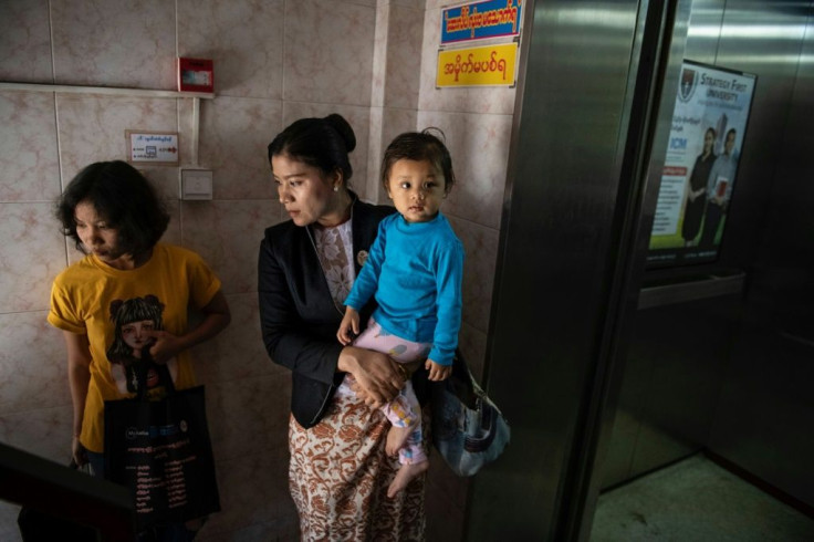 Hla Hla Yee holds her daughter before a meeting at the Gender Equality Network office in Yangon