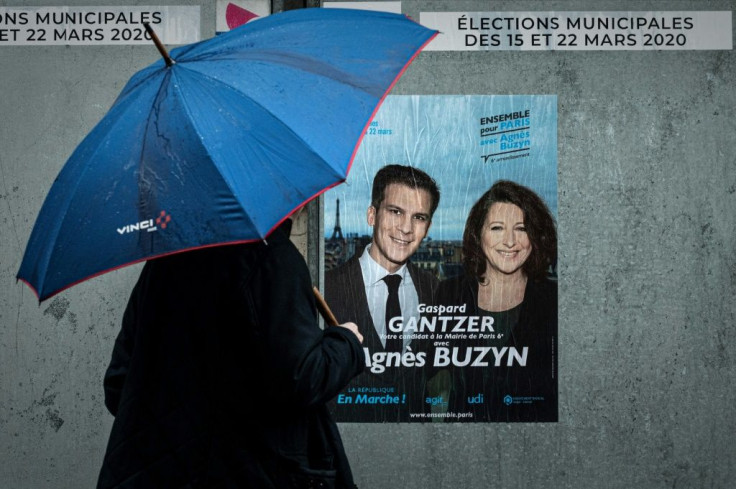 A man passes electoral poster ahead of the first round of the mayoral elections in Paris, as polls show Socialist incumbent Anne Hidalgo leading the race