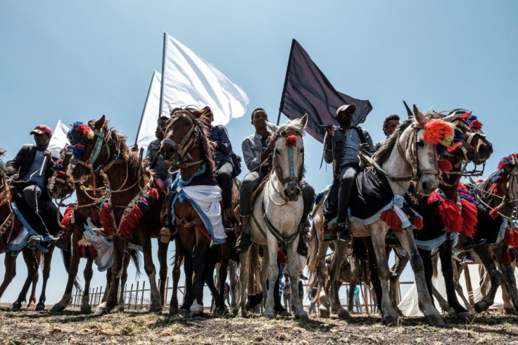 Horsemen carried black and white flags as they rode around the crash site