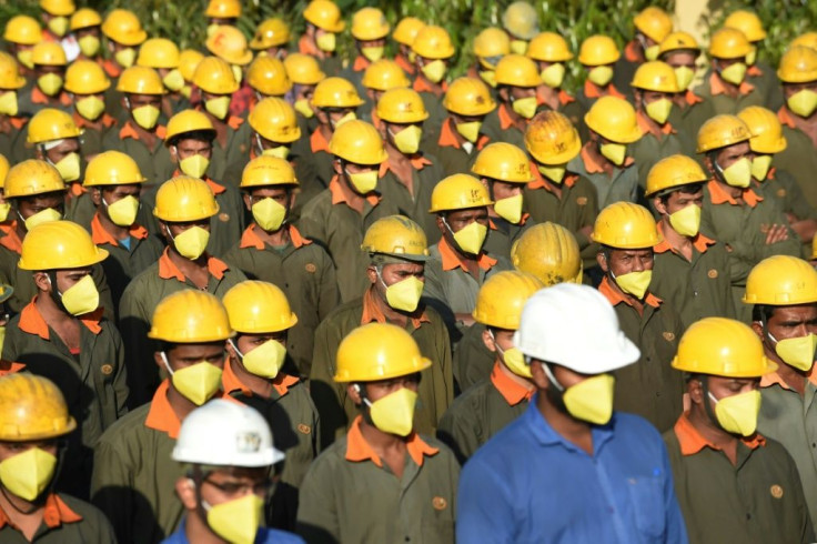 Workers don masks at a factory in Vasna Buzarg, India, as the rapidly spreading coronavirus fans fears over the global economy