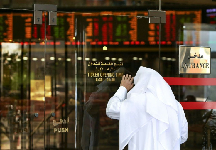 A trader checks stock prices from the outside after authorities closed the Boursa Kuwait on March 8