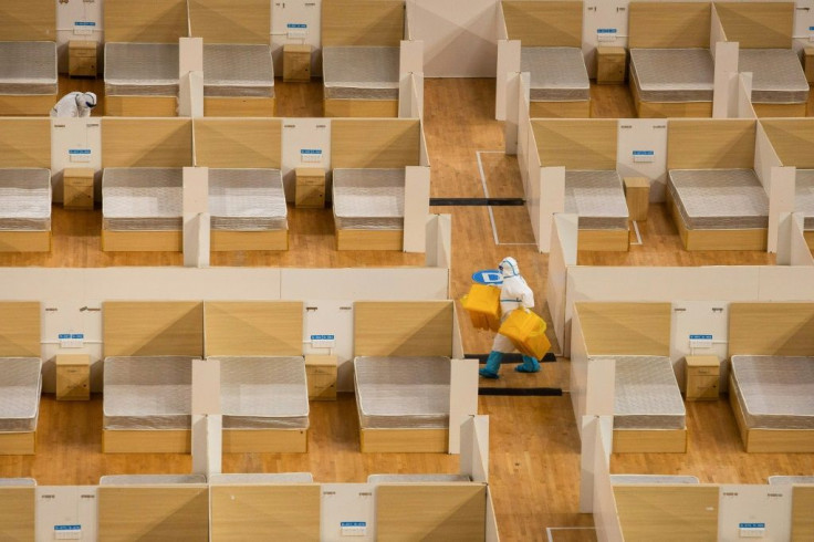 A staff member removes waste after the final patients were discharged from a temporary hospital set up to treat people with the COVID-19 coronavirus in a sports stadium in Wuhan