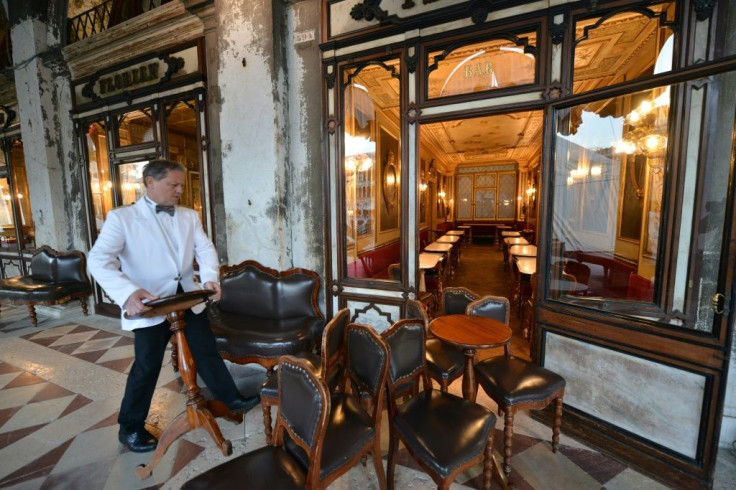 Waiters move tables and chairs inside the Cafe Florian in Saint Mark Square in Venice, after millions of people were placed under forced quarantine in northern Italy