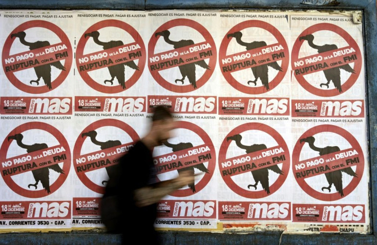 A man walks by posters portraying the International Monetary Fund as vultures in Buenos Aires