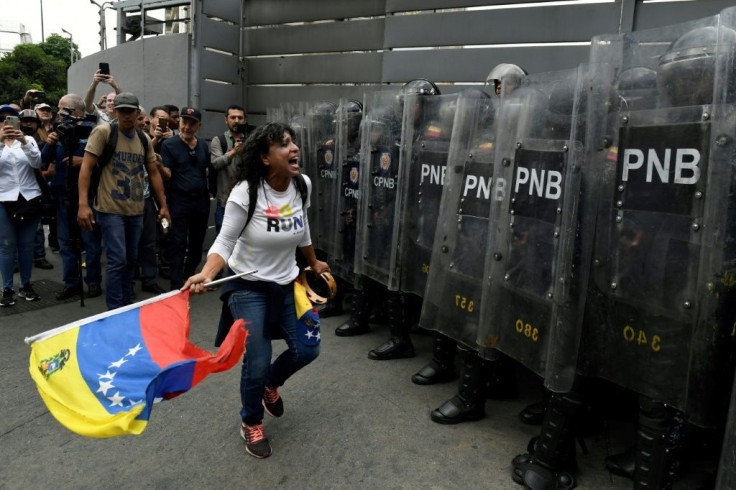 Supporters of Venezuelan opposition leader Juan Guaido confront Venezuelan security forces blocking their path in Caracas