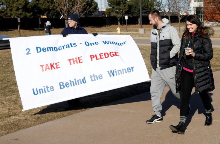 Tom Moran holds a sign urging Democrats to unite at a rally for Bernie Sanders in Dearborn, Michigan