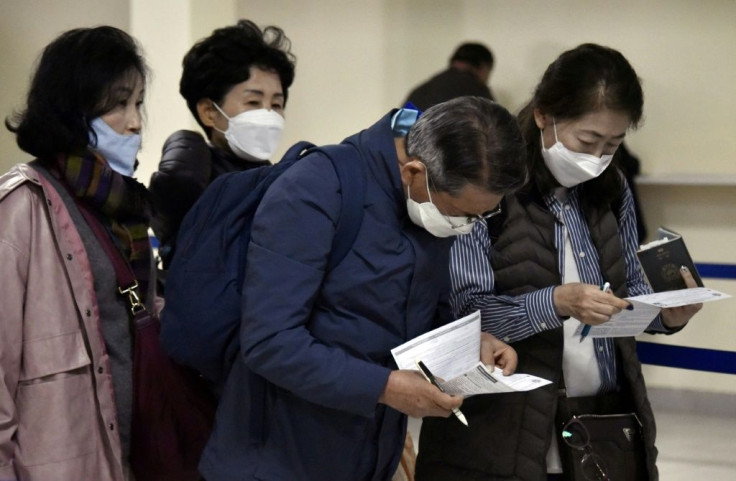 Passengers arriving at Bolivia's El Alto international airport wear protective face masks