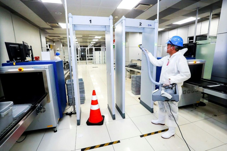 Health ministry workers spraying sanitizer at San Salvador's international airport on March 5, 2020