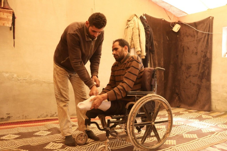 Ali's younger brother helps him get around in the wheel chair he has used since he lost his legs to a landmine explosion