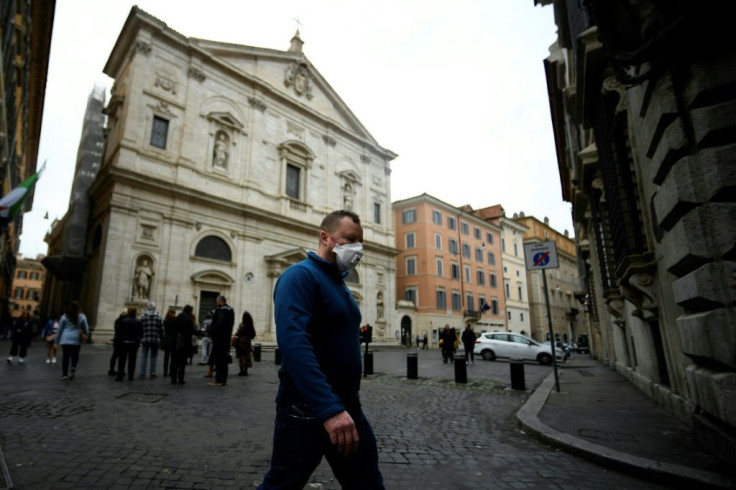 A man wearing a protective mask walks past the Church of St. Louis of the French (San Luigi dei Francesi) in Rome on March 1, 2020