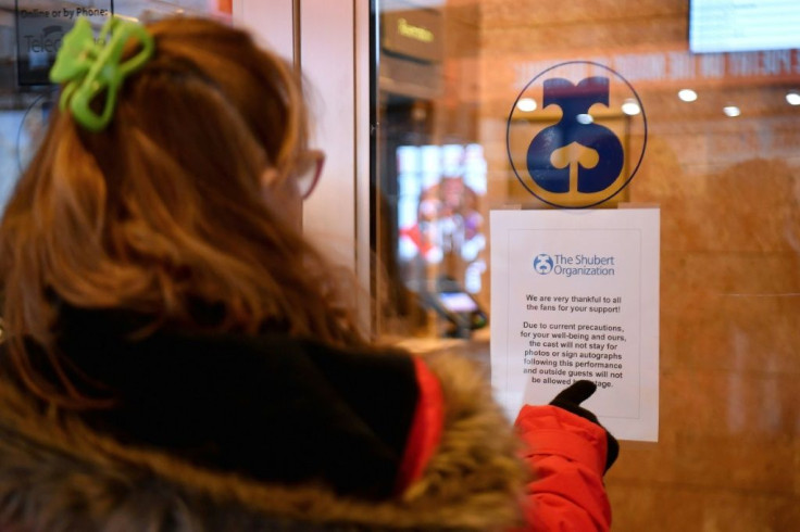 A woman reads a sign at Shubert Theater in New York's Broadway theater district announcing closures over coronavirus