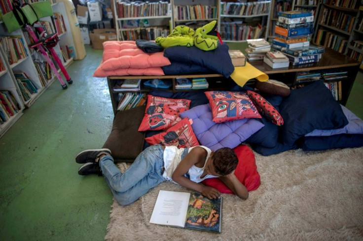 A boy reads a book at the "Lua's World" library
