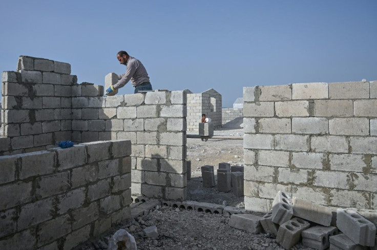 A worker lays a brick at the construction site of a camp for displaced Syrians created by Turkey's Humanitarian Relief Foundation (IHH)