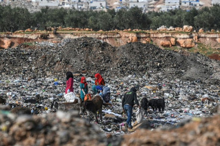 Syrians rummage through a landfill in Kafr Lusin village on the border with Turkey in Syria's Idlib on March 10