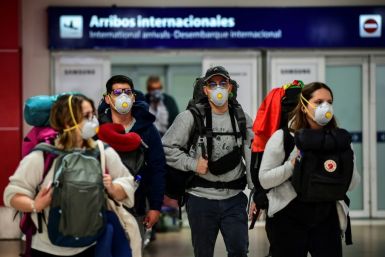Passengers wearing face masks arrive at Ezeiza International Airport in Buenos Aires
