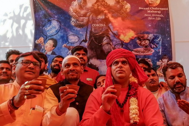 Members of All India Hindu Mahasabha staged fire rituals and drank cow urine in New Delhi Saturday to fight COVID-19