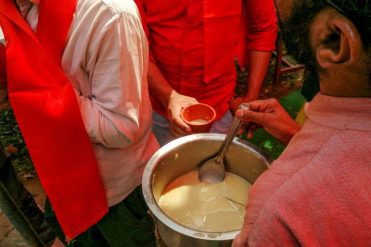 A man serves a traditional Hindu ritual mixture made of cow dung, urine, milk, curd and ghee in Delhi on Saturday