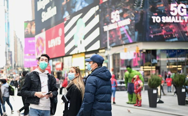 People wearing masks visit New York's Times Square on March 14, 2020