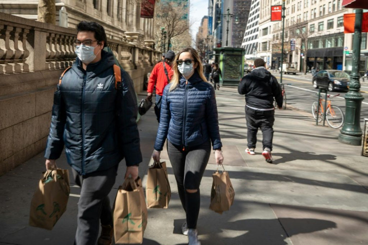 People carry groceries in New York City while wearing face masks and gloves on March 14