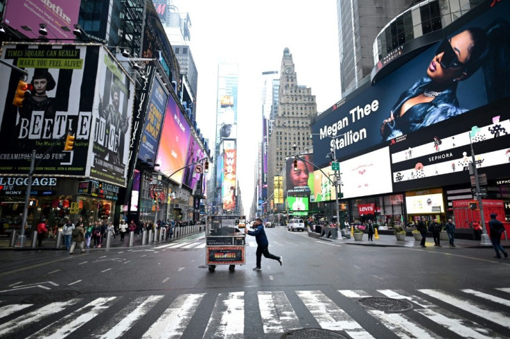 A food vendor pushes his cart across an emptier than usual Times Square on March 13