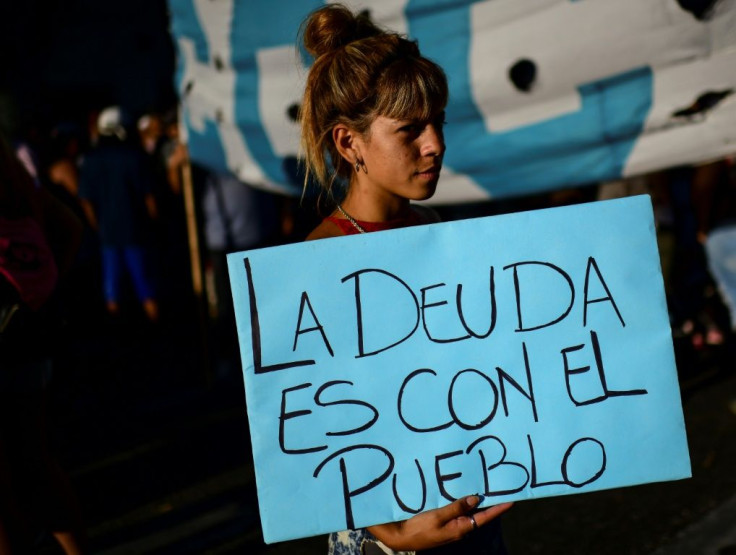 A woman holds a sign declaring "the debt is with the people" at a protest against the IMF in Buenos Aires on February 12