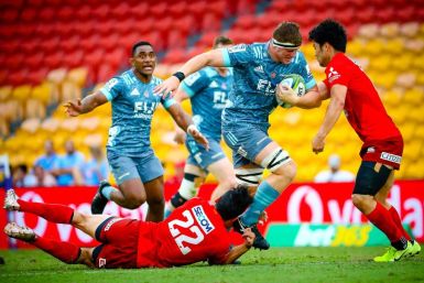 Canterbury Crusaders' Tom Sanders is tackled by Japan Sunwolves' Shogo Nakano and Keisuke Moriya (right) in front of a sparse crowd at Brisbane on Saturday, hours before the Super Rugby season was suspended