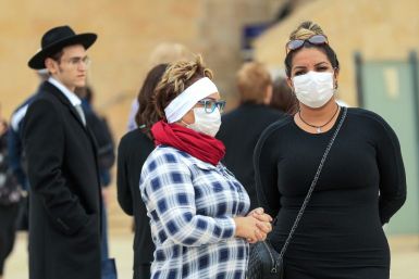 Women wearing protective masks pay a visit to the nearly deserted Western Wall, Judaism's holiest site, after Israel imposed some of the world's tightest restrictions to contain COVID-19 coronavirus disease