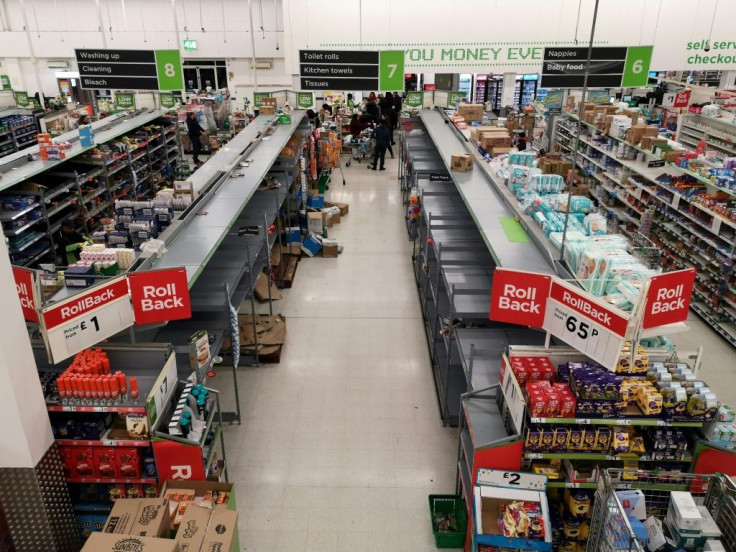 Empty shelves are pictured in the toilet roll/kitchen towel aisle of a supermarket in London on March 13, 2020