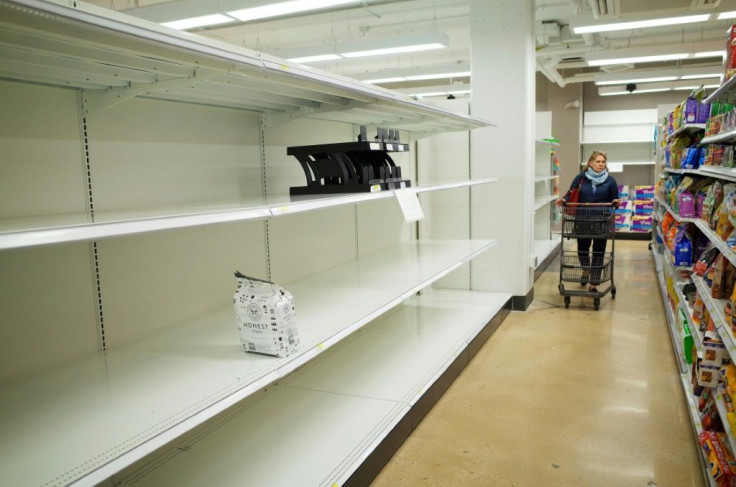 A shopper walks down an aisle with empty shelves for toilet paper at a Target store in Bethesda, Maryland on March 16, 2020