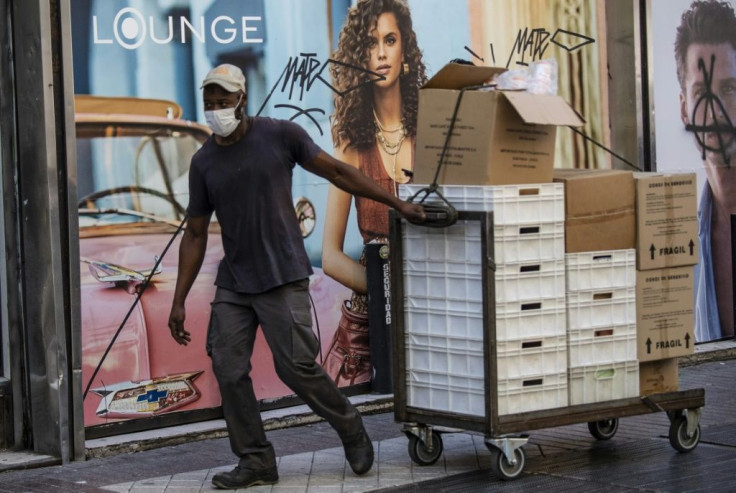 A worker wears a face mask as a precautionary measure against the spread of the new coronavirus as he pulls a cart with boxes near La Moneda Presidential Palace in Santiago, on March 16, 2020