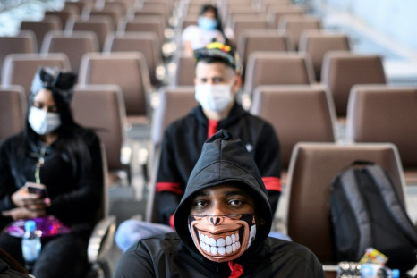A man wearing a facemask as a preventative measure following a coronavirus outbreak which began in the Chinese city of Wuhan sits at a Hong Kong cruise terminal in February 2020