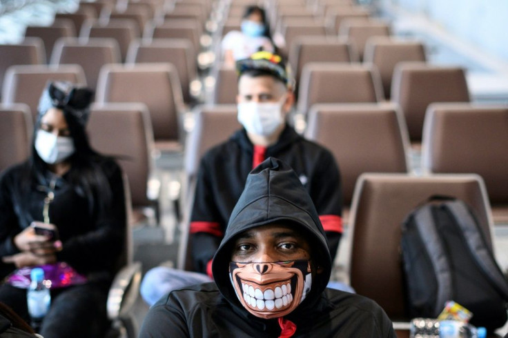 A man wearing a facemask as a preventative measure following a coronavirus outbreak which began in the Chinese city of Wuhan sits at a Hong Kong cruise terminal in February 2020