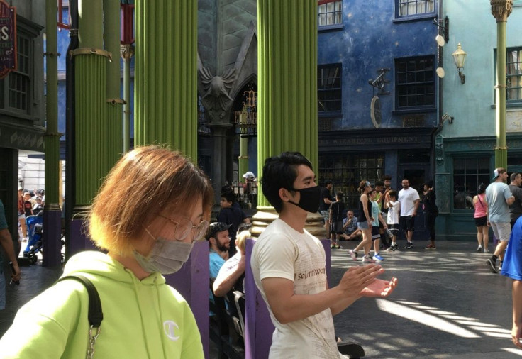 Tourists wear masks as they visit the Universal Studios theme park in Orlando, Florida, a state that is holding its Democratic presidential primary on March 17, 2020 despite widespread coronavirus outbreaks