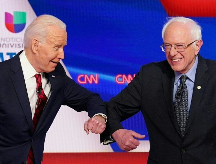 Democratic presidential hopefuls former US vice president Joe Biden (L) and Senator Bernie Sanders greet each other with a safe elbow bump before the start of the Democratic presidential debate on March 15, 2020