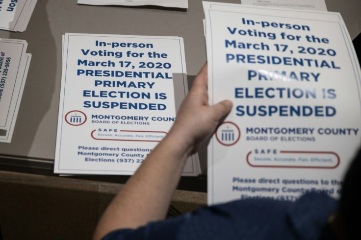 Election workers hand out "election delayed" signs to put up at polling stations in Dayton, Ohio -- the state's governor says the primary will be held at a later date