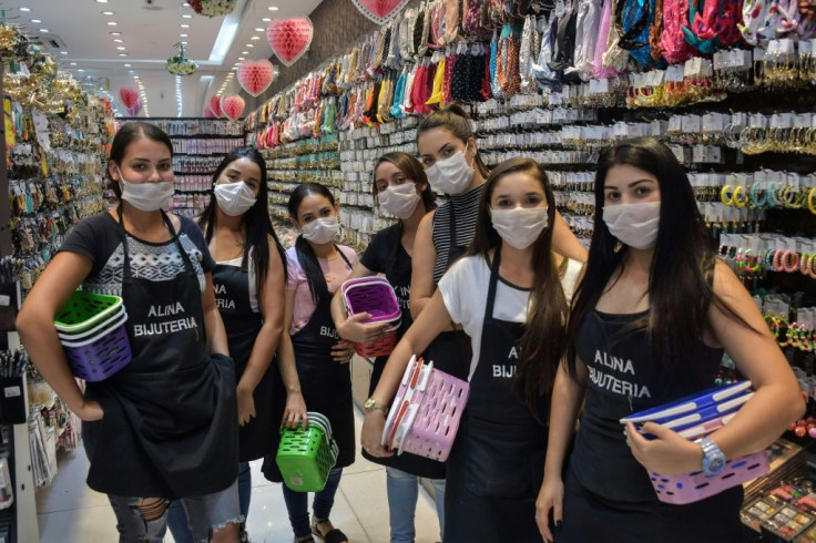 Shop sellers wear masks in the Brazilian city of Sao Paulo, where a state of emergency has been declared over the coronavirus pandemic