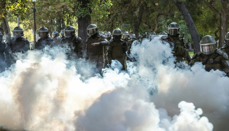Demonstrators clash with Chilean riot police during a protest against Chilean President Sebastian Pinera's government in Santiago, on March 13, 2020.