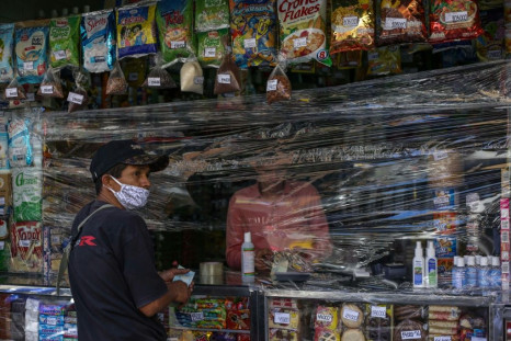A man shops at a store covered with plastic as a precautionary measure against the spread of the new coronavirus, COVID-19, in Caracas, on March 17, 2020President Nicolas Maduro asked the International Monetary Fund on Tuesday for a $5 billion loan to hel