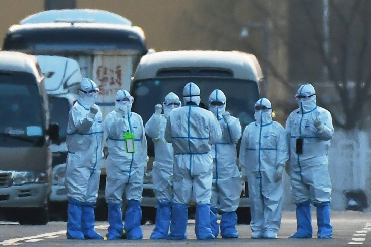 Workers at a registration and screening center for processing people before transferring them to quarantine are pictured after loading travellers onto buses near Beijing Capital Airport