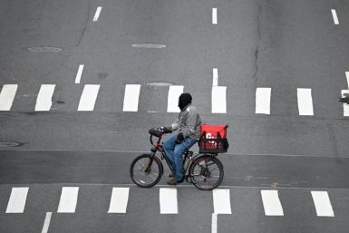 A food delivery man crosses 1st Avenue in Manhattan on March 17, 2020  in New York City